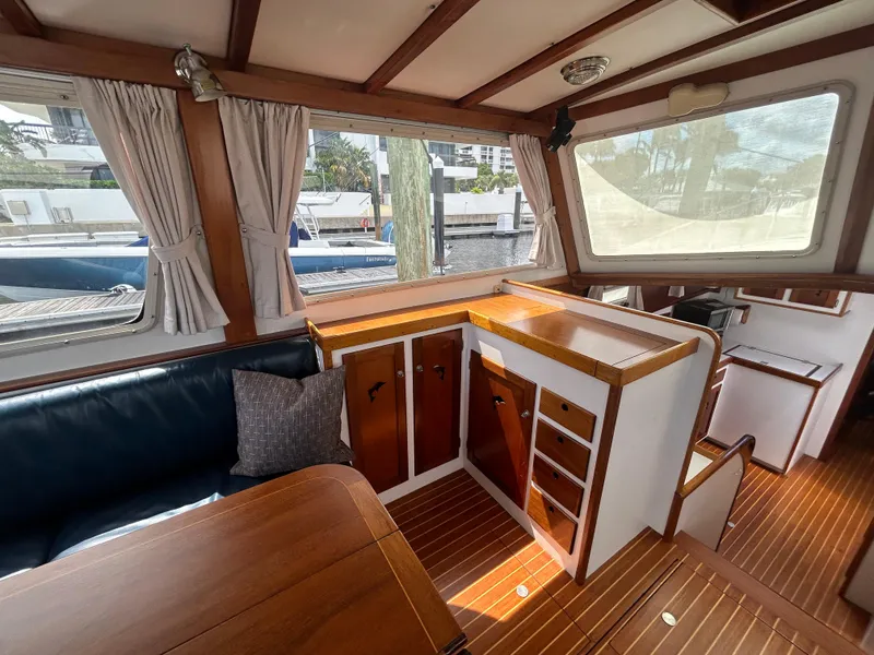Slide: The Image of Interior of 1987 Lyman-Morse Downeast Flybridge yacht with wood finish and seating area. - 14