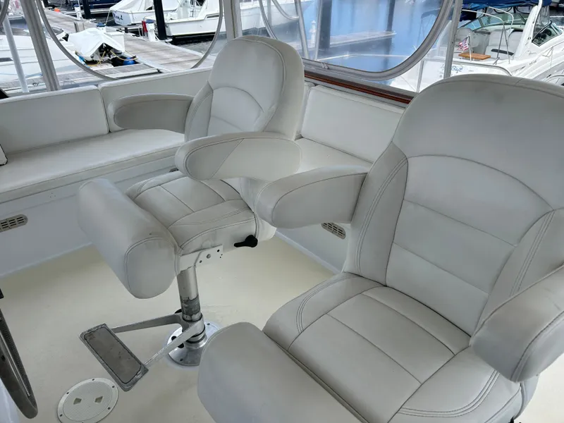 Slide: The Image of 1987 Lyman-Morse Downeast Flybridge with white leather seating and helm chairs. - 28