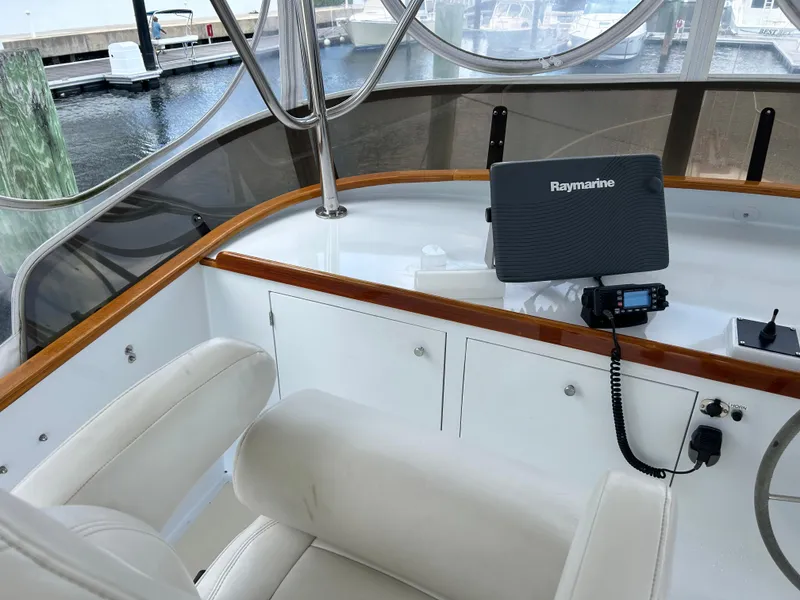 Slide: The Image of 1987 Lyman-Morse Downeast Flybridge helm with Raymarine equipment and white seating. - 34