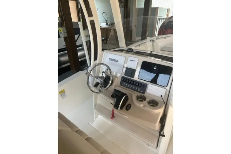 Slide: The Image of 2024 Boston Whaler 250 Dauntless boat console with steering wheel and navigation controls. - 10