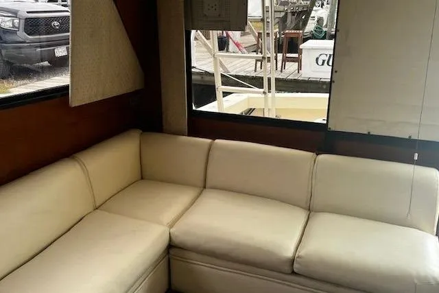 Slide: The Image of 1988 Viking 45 Convertible yacht interior with cream leather sofa and marina view. - 11