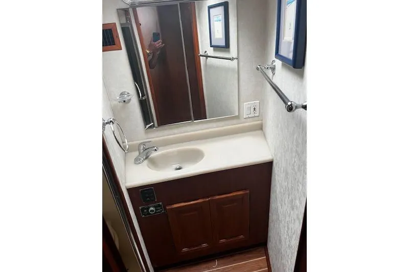 Slide: The Image of 1988 Viking 45 Convertible bathroom with sink, mirror, and wooden cabinetry. - 17