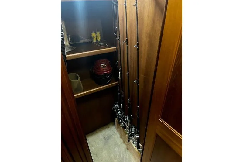 Slide: The Image of Fishing rods stored in a wooden cabinet on a 1988 Viking 45 Convertible boat. - 19