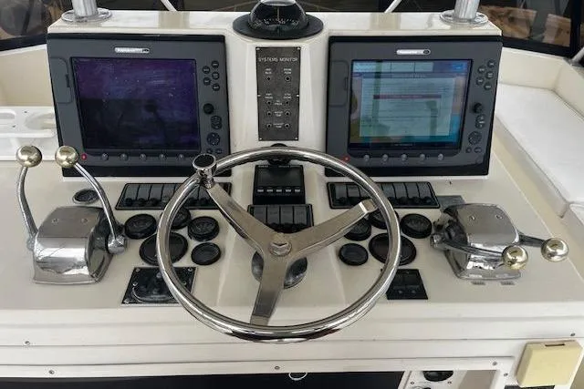 Slide: The Image of Control panel of 1988 Viking 45 Convertible boat with dual screens and steering wheel. - 29