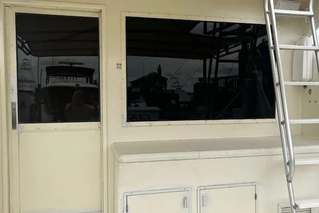 Slide: The Image of 1988 Viking 45 Convertible boat exterior with ladder and windows, showcasing sleek design. - 6