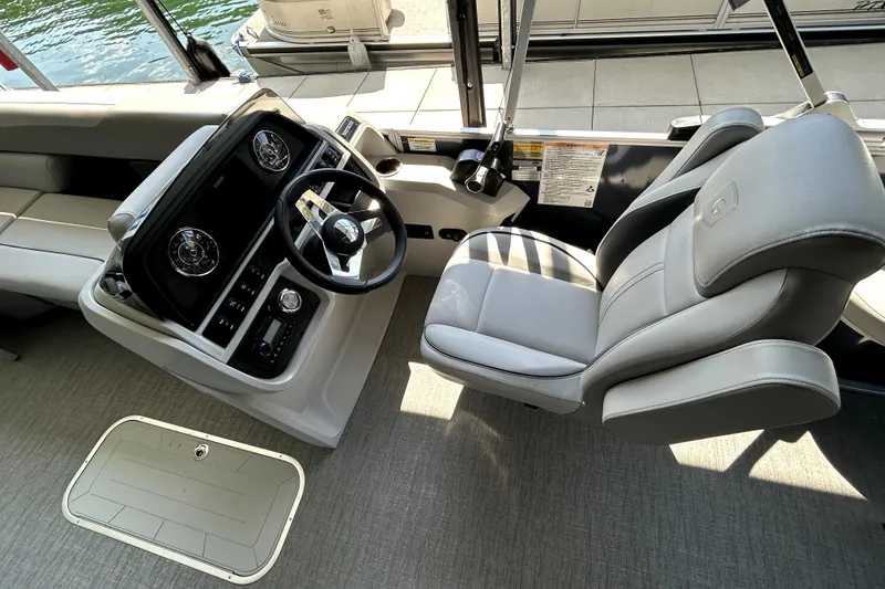 Slide: The Image of 2025 Godfrey SWEETWATER 2286 SFL boat interior with steering wheel and captain's chair. - 12