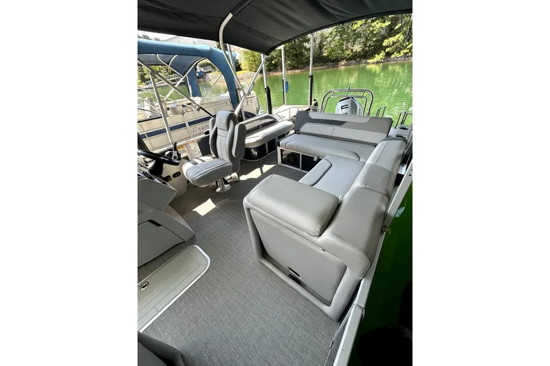 Slide: The Image of 2025 Godfrey SWEETWATER 2286 SFL pontoon boat interior with plush seating and helm. - 14