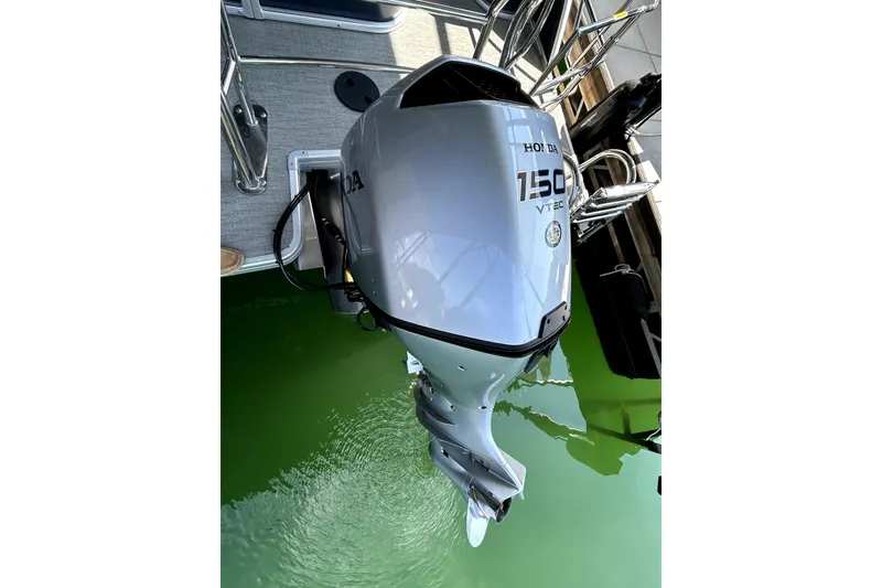 Slide: The Image of Outboard motor on 2025 Godfrey SWEETWATER 2286 SFL pontoon boat, docked in green water. - 7