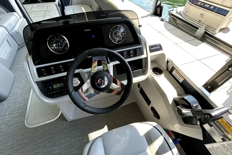Slide: The Image of 2025 Godfrey SWEETWATER 2286 SFL boat dashboard with steering wheel and controls. - 8