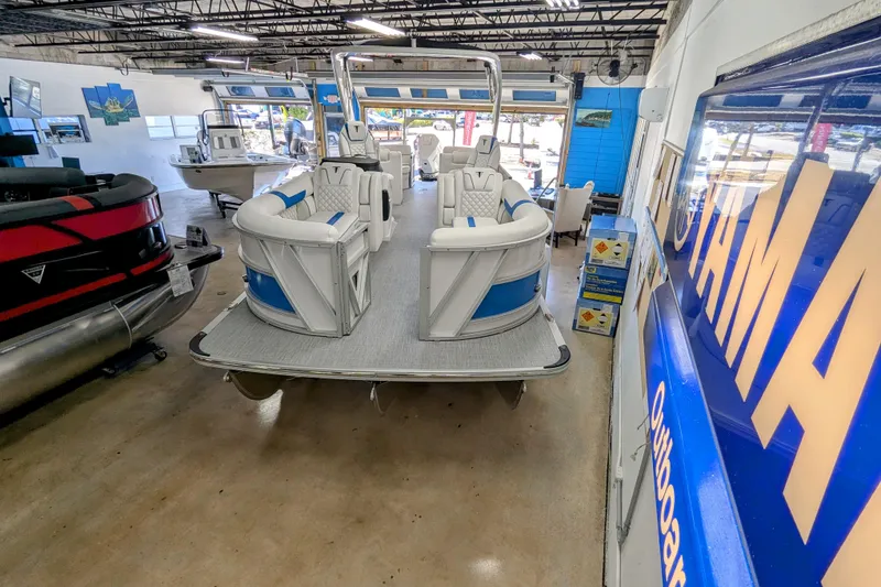 Slide: The Image of 2026 Trifecta 25 RF SS Arch pontoon boat displayed in a showroom. - 2