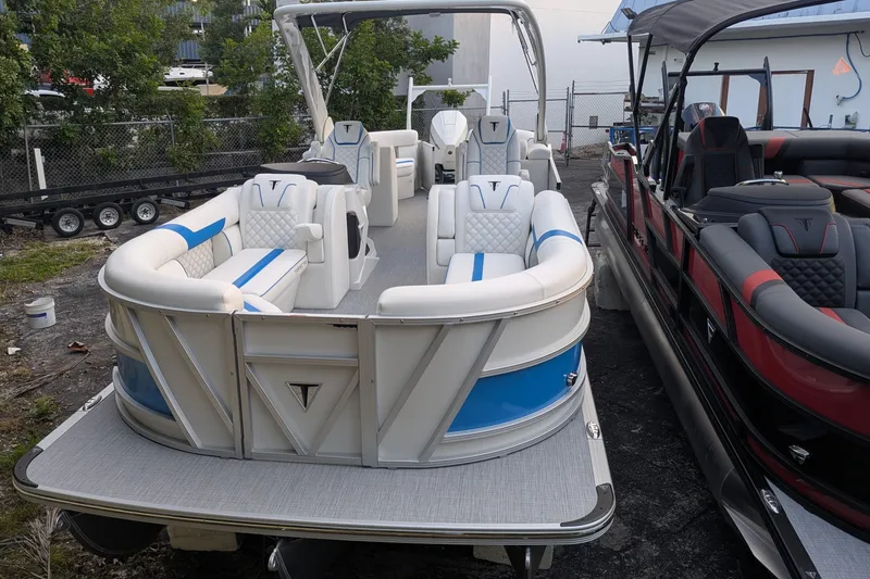 Slide: The Image of 2026 Trifecta 25 RF SS Arch pontoon boat with white and blue seating, docked outdoors. - 5