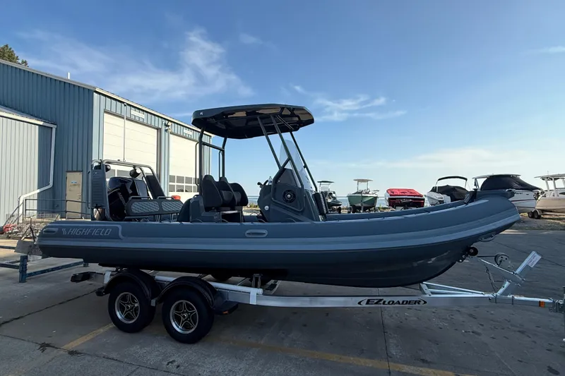 The Image of 2025 Highfield Sport 660 boat on trailer, parked outdoors near other boats. - 5
