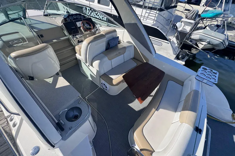 Slide: The Image of 2008 Sea Ray 350 Sundancer boat interior with seating, table, and helm at marina. - 13