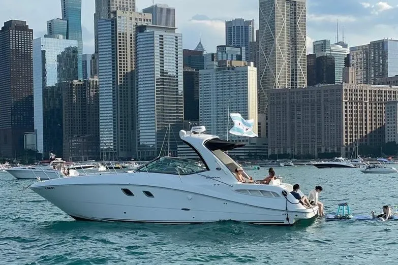 Slide: The Image of 2008 Sea Ray 350 Sundancer yacht on water with city skyline backdrop. - 2