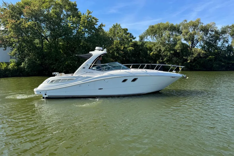 Slide: The Image of 2008 Sea Ray 350 Sundancer cruising on a calm river with lush green trees. - 54