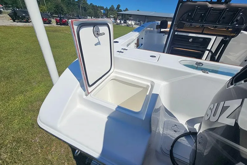 Slide: The Image of 2026 Sea Pro 242 Center Console Sport boat with open storage compartment and Suzuki engine. - 11