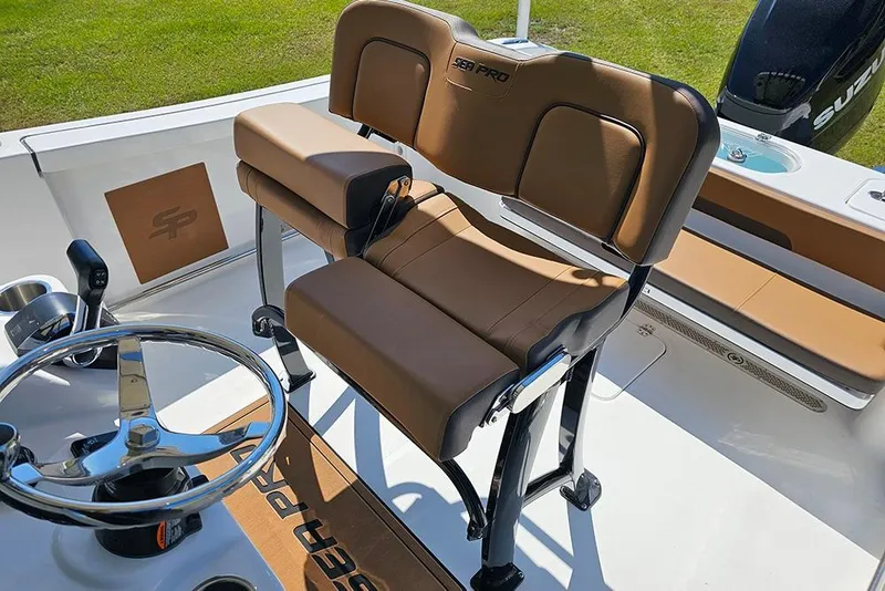 Slide: The Image of 2026 Sea Pro 242 Center Console Sport boat interior with brown seating and steering wheel. - 18