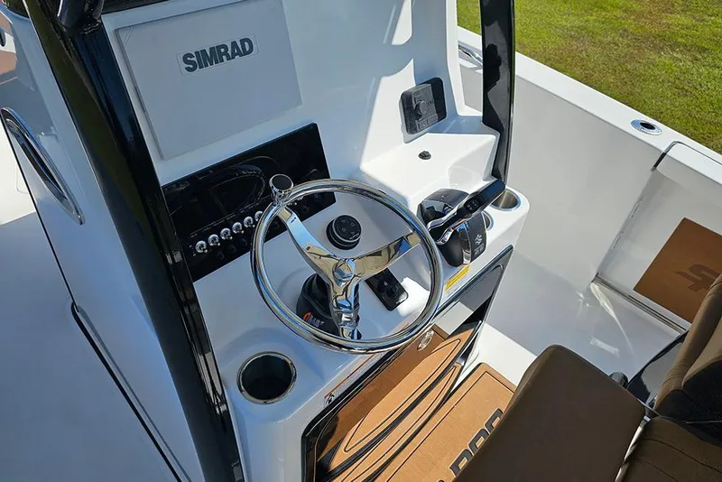 Slide: The Image of 2026 Sea Pro 242 Center Console Sport boat dashboard with Simrad electronics and steering wheel. - 20