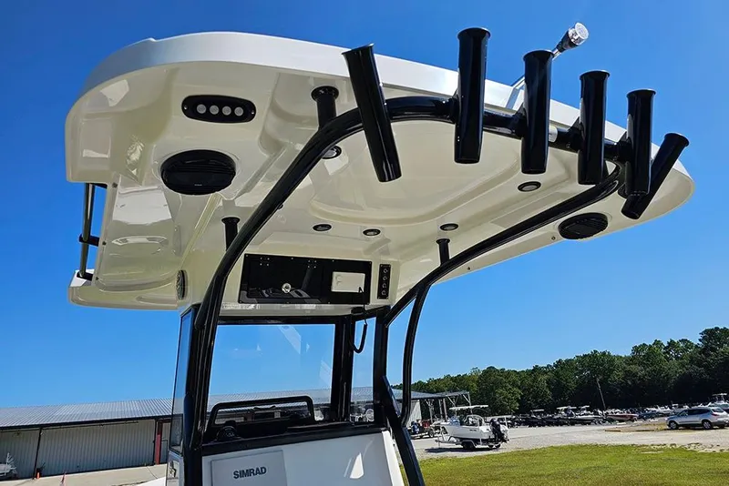 Slide: The Image of 2026 Sea Pro 242 Center Console Sport boat with rod holders and electronics, under clear blue sky. - 24