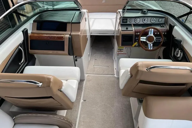 Slide: The Image of 2011 Four Winns SL262 boat interior with beige and white seating, steering wheel, and dashboard. - 10