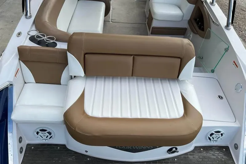 Slide: The Image of 2011 Four Winns SL262 boat interior with tan and white seating, cup holders, and speakers. - 12
