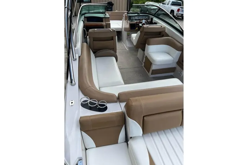 Slide: The Image of 2011 Four Winns SL262 boat interior with tan and white seating, cup holders, and dashboard view. - 13