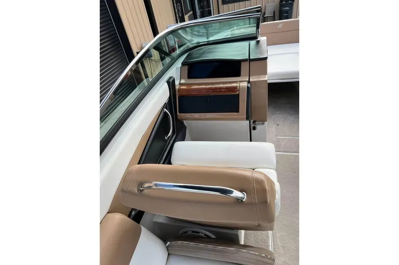 Slide: The Image of 2011 Four Winns SL262 boat interior with tan and white seating, sleek dashboard, and modern design. - 14
