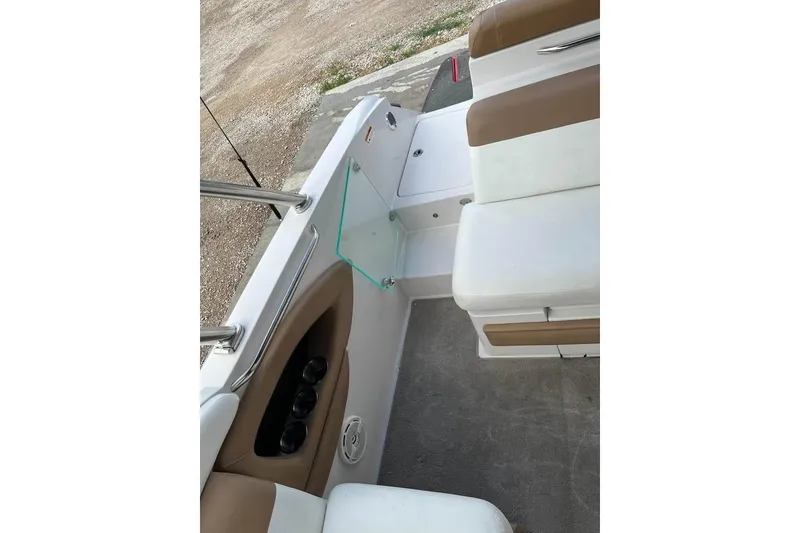 Slide: The Image of 2011 Four Winns SL262 boat interior with white and tan seating, cup holders, and carpeted floor. - 6