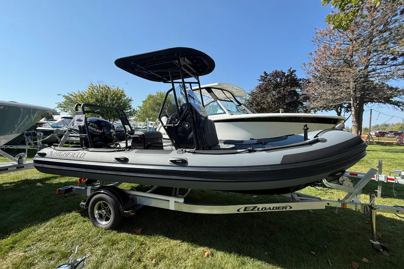 The Image of 2025 Highfield Patrol 540 boat on trailer, displayed outdoors under clear blue sky. - 1