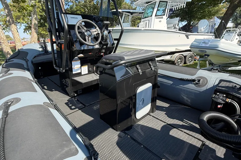 Slide: The Image of 2025 Highfield Patrol 540 boat interior with steering console and seating, displayed outdoors. - 5
