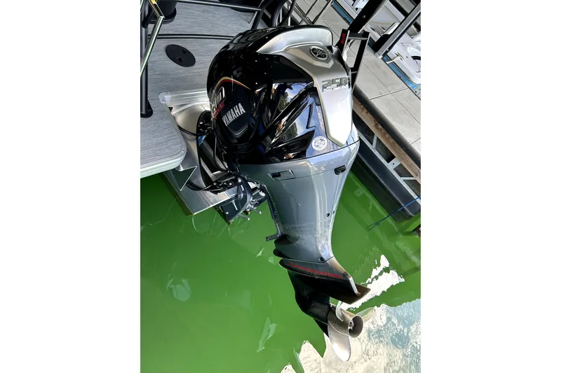 Slide: The Image of Outboard motor on 2026 Godfrey Sweetwater 2486 SFLC pontoon boat, docked in green water. - 15