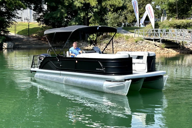 Slide: The Image of 2026 Godfrey Sweetwater 2486 SFLC pontoon boat on a serene lake. - 2