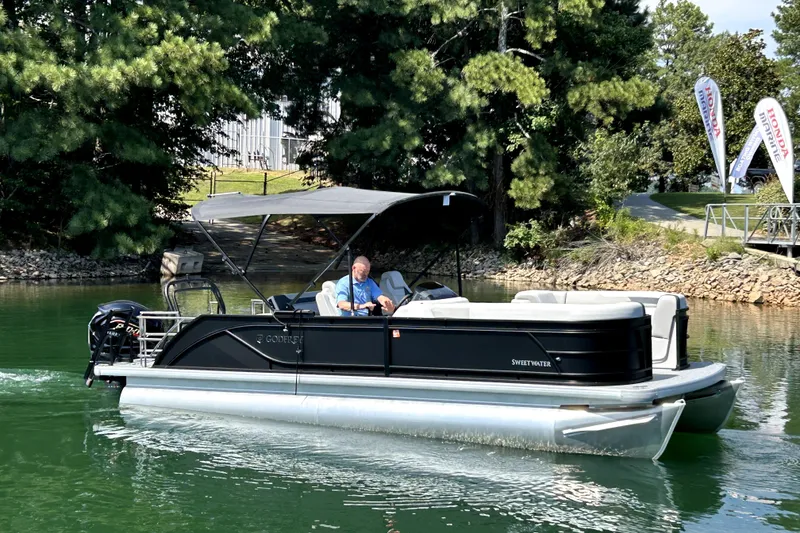 Slide: The Image of 2026 Godfrey Sweetwater 2486 SFLC pontoon boat cruising on a serene lake. - 4