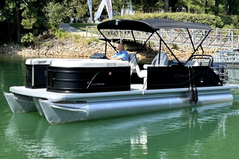 Slide: The Image of 2026 Godfrey Sweetwater 2486 SFLC pontoon boat cruising on a serene lake. - 5