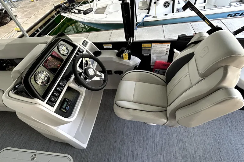 Slide: The Image of 2026 Godfrey Sweetwater 2486 SFLC boat interior with steering wheel and captain's chair. - 9