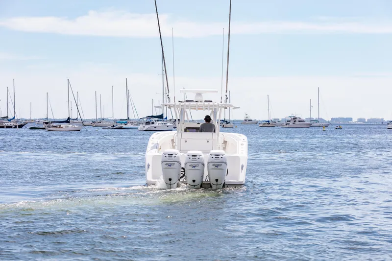 Slide: The Image of 2020 SeaHunter 33 Tournament boat cruising in a marina with multiple sailboats. - 2