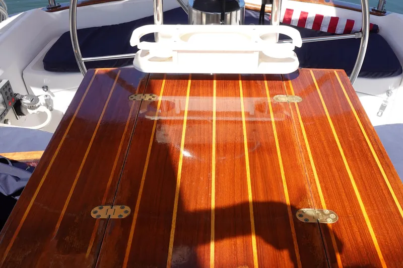 Slide: The Image of Polished wooden table on 1987 Tartan Marine 40 sailboat deck, with nautical seating. - 11