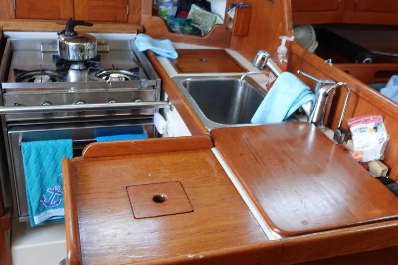 Slide: The Image of 1987 Tartan Marine 40 yacht kitchen with stove, sink, and wooden countertops. - 27