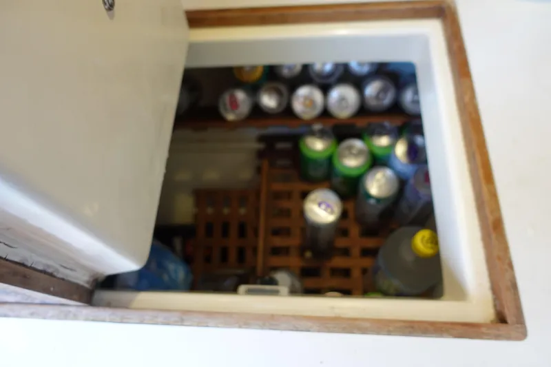 Slide: The Image of Beverage storage compartment on 1987 Tartan Marine 40 yacht, filled with assorted cans and bottles. - 28