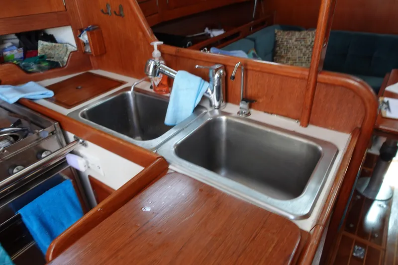 Slide: The Image of 1987 Tartan Marine 40 yacht kitchen with dual sinks and wooden cabinetry. - 30