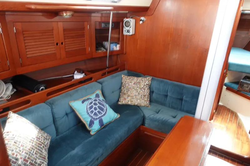 Slide: The Image of Interior of 1987 Tartan Marine 40 yacht with blue cushioned seating and wooden cabinetry. - 33