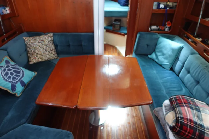 Slide: The Image of Cozy 1987 Tartan Marine 40 yacht interior with blue seating and wooden table. - 35