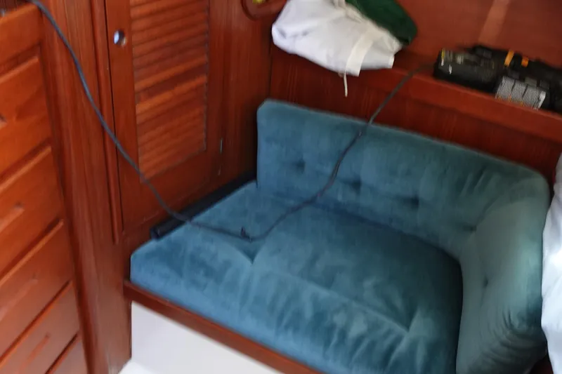 Slide: The Image of Interior of 1987 Tartan Marine 40 sailboat with blue cushioned seating and wooden cabinetry. - 36