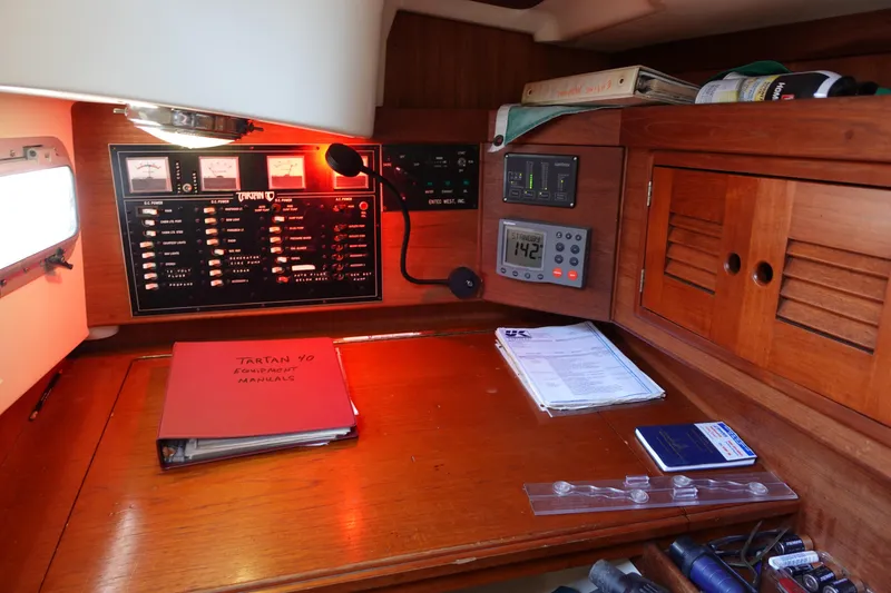 Slide: The Image of Navigation station of a 1987 Tartan Marine 40 sailboat with equipment manuals and control panels. - 40