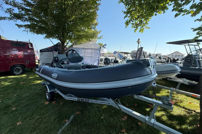 Slide: The Image of 2025 Highfield Classic 400 inflatable boat on display, parked on a trailer under a tree. - 4