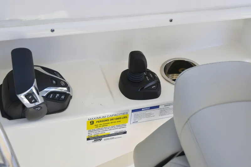 Slide: The Image of 2024 Pursuit DC 246 Dual Console boat controls and capacity label, seating visible. - 10