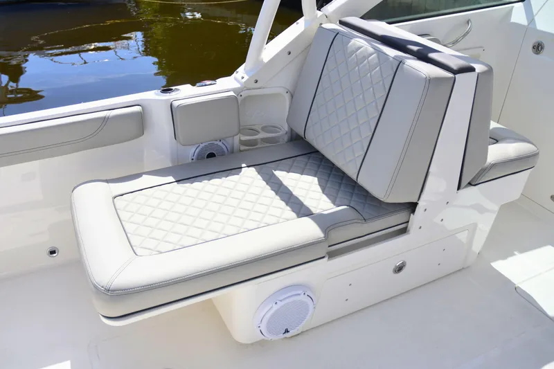 Slide: The Image of 2024 Pursuit DC 246 Dual Console boat interior with cushioned seating and cup holders. - 6
