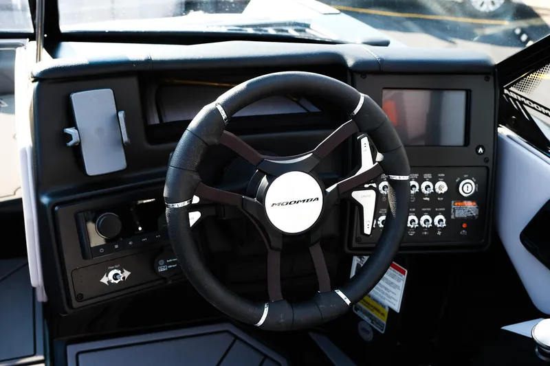 Slide: The Image of 2024 Moomba Tykon boat dashboard with steering wheel and control panel. - 17