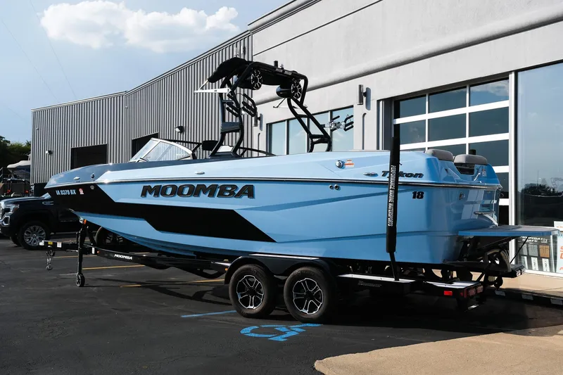 Slide: The Image of 2024 Moomba Tykon boat in blue, parked on a trailer outside a building. - 3