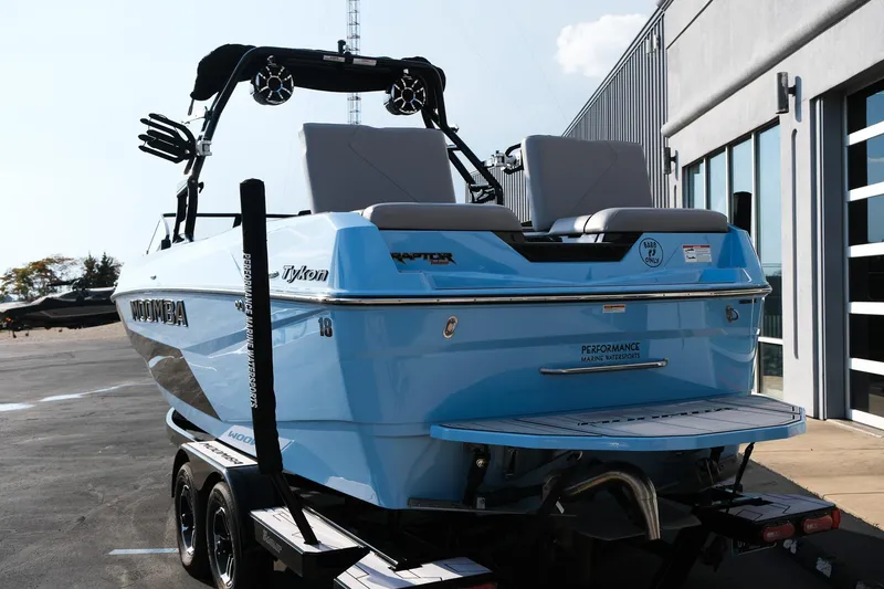 Slide: The Image of 2024 Moomba Tykon boat in blue, parked on a trailer near a building. - 8